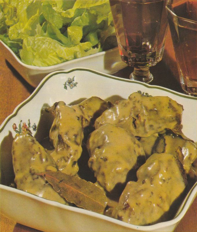 Gebratene Hasenrücken-Stücke in glänzender Sahne-Rotwein-Sauce auf einer weißen Servierplatte mit grünem Blumendekor. Im Hintergrund eine Schale mit grünem Blattsalat und ein Wasserglas auf einem Holztablett.